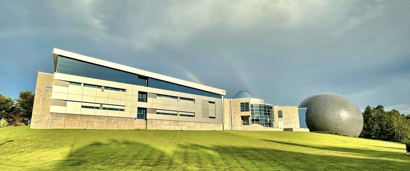 Genesis Science Network campus building under a double rainbow